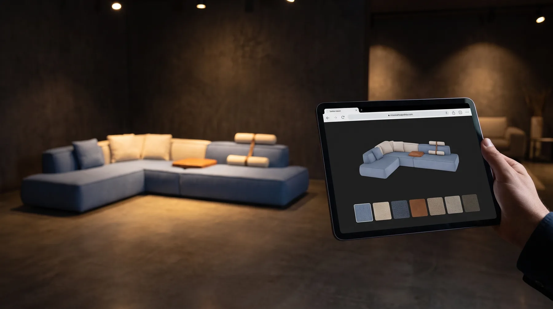 A tablet in a showroom showing a product page with a 3D sofa, the real sofa behind it